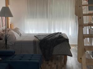a bedroom with a bed and a window at Huelintown in Málaga