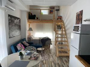 a small living room with a loft bed and a kitchen at Huelintown in Málaga