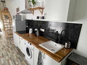 a kitchen with a sink and a washer and dryer at Huelintown in Málaga