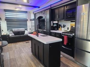 a kitchen with black cabinets and a stove top oven at Grand Canyon RV Glamping in Williams