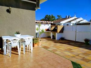 eine Terrasse mit einem weißen Tisch und Stühlen auf einem Haus in der Unterkunft Riumar "Josef", 490m to beach, private pool, On-Site-Service, dog beach in Riumar