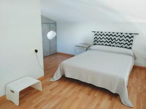 Schlafzimmer mit einem großen weißen Bett und Holzboden in der Unterkunft Riumar "Josef", 490m to beach, private pool, On-Site-Service, dog beach in Riumar