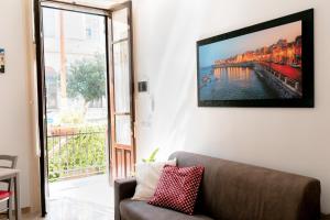 a living room with a couch and a television on a wall at Ecalù Siracusa in Siracusa