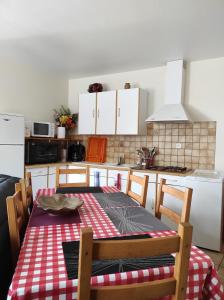 a kitchen with a table with a red and white checkered table cloth at La guguenaie in Béganne