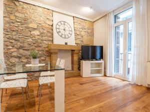 a living room with a stone wall and a table and chairs at San Telmo Oldtown by DLA in San Sebastián