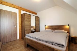 1 dormitorio con 1 cama grande y cabecero de madera en Horské apartmány Na Pastvinách, en Vaclavov u Bruntalu
