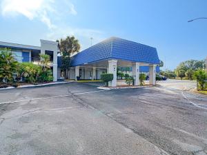 a building with a blue roof in a parking lot at Stayable Lakeland in Lakeland