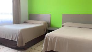 Postel nebo postele na pokoji v ubytování Sunrock Hotel & Suites