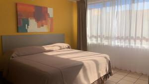 Postel nebo postele na pokoji v ubytování Sunrock Hotel & Suites