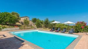 a large swimming pool with two chairs and umbrellas at Montebendico 4, Emma Villas in Castel del Piano