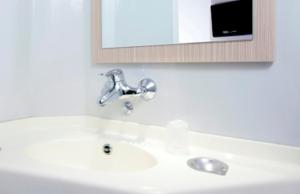 La salle de bains est pourvue d'un lavabo, d'un robinet et d'un miroir. dans l'établissement Premiere Classe Lyon Ouest - Tassin, à Tassin-la-Demi-Lune