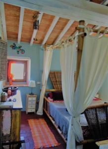 een slaapkamer met een bed met gordijnen en een bureau bij B&B Un posto nel mondo in Siena