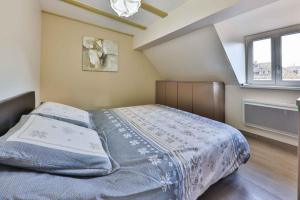 een slaapkamer met een bed en een raam bij Gîte -Coup de Cœur- 3 étoiles in Turckheim