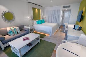 a hotel room with a bed and a couch at Paradisus Cancun All Inclusive in Cancún