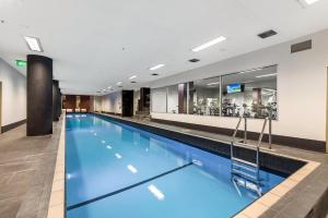 a large swimming pool with blue water at Docklands 2-Bed Near CBD & Marvel Stadium in Melbourne