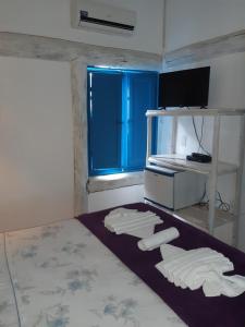 um quarto com três toalhas brancas no chão e uma janela em Pousada Casa da Praia Itaúnas em Itaúnas