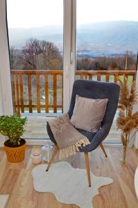 a blue chair with a pillow on a balcony at View Apartments Belasica in Mokrievo