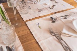 einen Tisch mit einem weißen Tischtuch und Besteck in der Unterkunft Spa&Aktiv Hotel Lavendel in Windischgarsten
