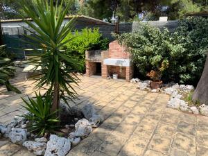 un giardino con patio in pietra con panca e piante di La Dimora in riva al mare a Vieste