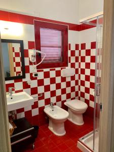 a bathroom with two toilets and a sink and a mirror at La Dimora in riva al mare in Vieste