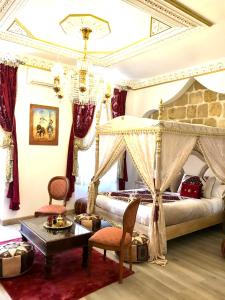 a bedroom with a canopy bed and two chairs at Suite Orientale Maison de L'église du Couvent in Narbonne