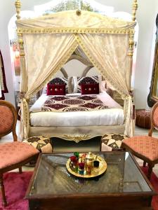 sypialnia z łóżkiem z baldachimem i stolikiem kawowym w obiekcie Suite Orientale Maison de L'église du Couvent w mieście Narbona