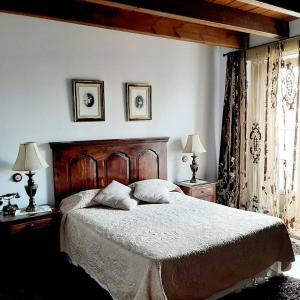 1 dormitorio con 1 cama grande, 2 mesas y 2 lámparas en La Posada Del Canal, en Villanueva de San Mancio