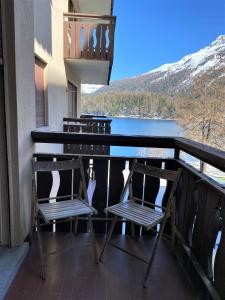 balkon z krzesłami i widokiem na jezioro w obiekcie Sonnalpine Apt 12 - Managed by TheSelectionist w Sankt Moritz