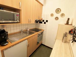 a small kitchen with a sink and a microwave at Sonnalpine Apt 12 - Managed by TheSelectionist in St. Moritz