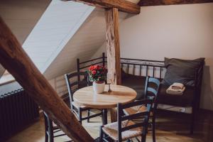 a wooden table with chairs and a table with flowers on it at Fotogrāfa Apartamenti in Kuldīga