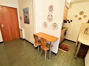 kuchnia ze stołem oraz 2 krzesłami i talerzami na ścianie w obiekcie Sonnalpine Apt 12 - Managed by TheSelectionist w Sankt Moritz
