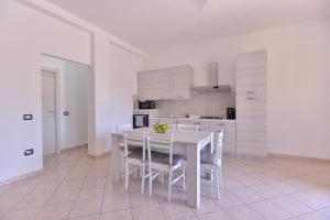 Una cocina blanca con una mesa y sillas blancas. en IzzHome Lagoon, en Pula