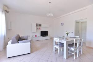 sala de estar blanca con mesa y sofá en IzzHome Lagoon, en Pula