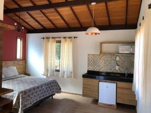 a bedroom with a bed and a sink at Chalés do Recanto in São João del Rei