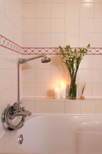 a bath tub with a vase of flowers and candles at Quinta Amarela - B&B in Nazaré