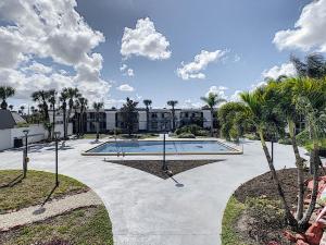 un patio con piscina y palmeras en Stayable Orlando at Florida Mall, en Orlando