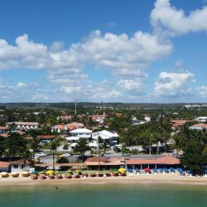 a beach with chairs and umbrellas and a resort at Areia do Atlantico Hotel in Porto Seguro