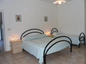 een slaapkamer met 2 bedden en 2 lampen op tafels bij Appartamenti Le Foci in Portoferraio