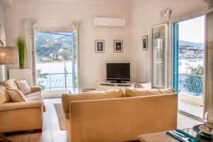 a living room with a couch and a television at Beautiful house by the sea in Poros