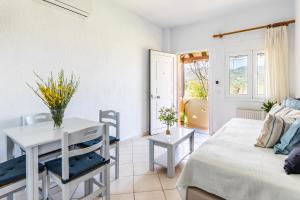 Sala de estar con cama y mesa en Lithos Apartments, en Skopelos Town