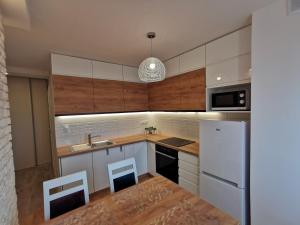 a kitchen with white appliances and wooden cabinets at Apartament D&T City Center View in Rzeszów