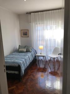 um quarto com uma cama, uma mesa e uma cadeira em Excelente dpto para 4/6 personas a metros de peatonal. em Mendoza