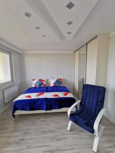 sypialnia z łóżkiem i niebieskim krzesłem w obiekcie Apartament D&T City Center View w mieście Rzeszów