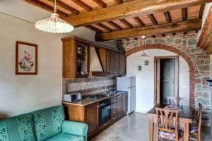 eine Küche mit einem Sofa und einem Tisch in einem Zimmer in der Unterkunft IL POZZO SUL COLLE in Rigomagno