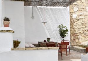 een patio met een tafel en stoelen en een gordijn bij Casa Almara in Espejo
