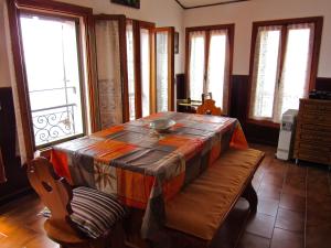 a dining room with a table and chairs and windows at Casa Emanuela 1 in Baiardo