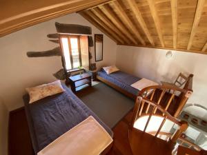 an attic room with two beds and a window at Quinta Perpetua, Casa Corvo in Alto do Sul
