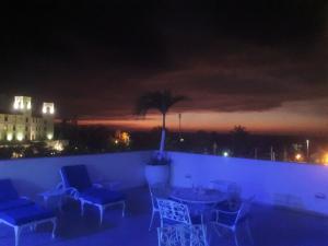 a patio with chairs and a table at night at Coral Reef Hotel in Cartagena de Indias