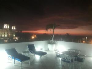 a room with chairs and a table on a balcony at night at Coral Reef Hotel in Cartagena de Indias