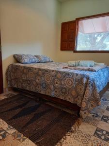 ein großes Bett in einem Zimmer mit Fenster in der Unterkunft Chalé Veredas e Buritis in Pirenópolis